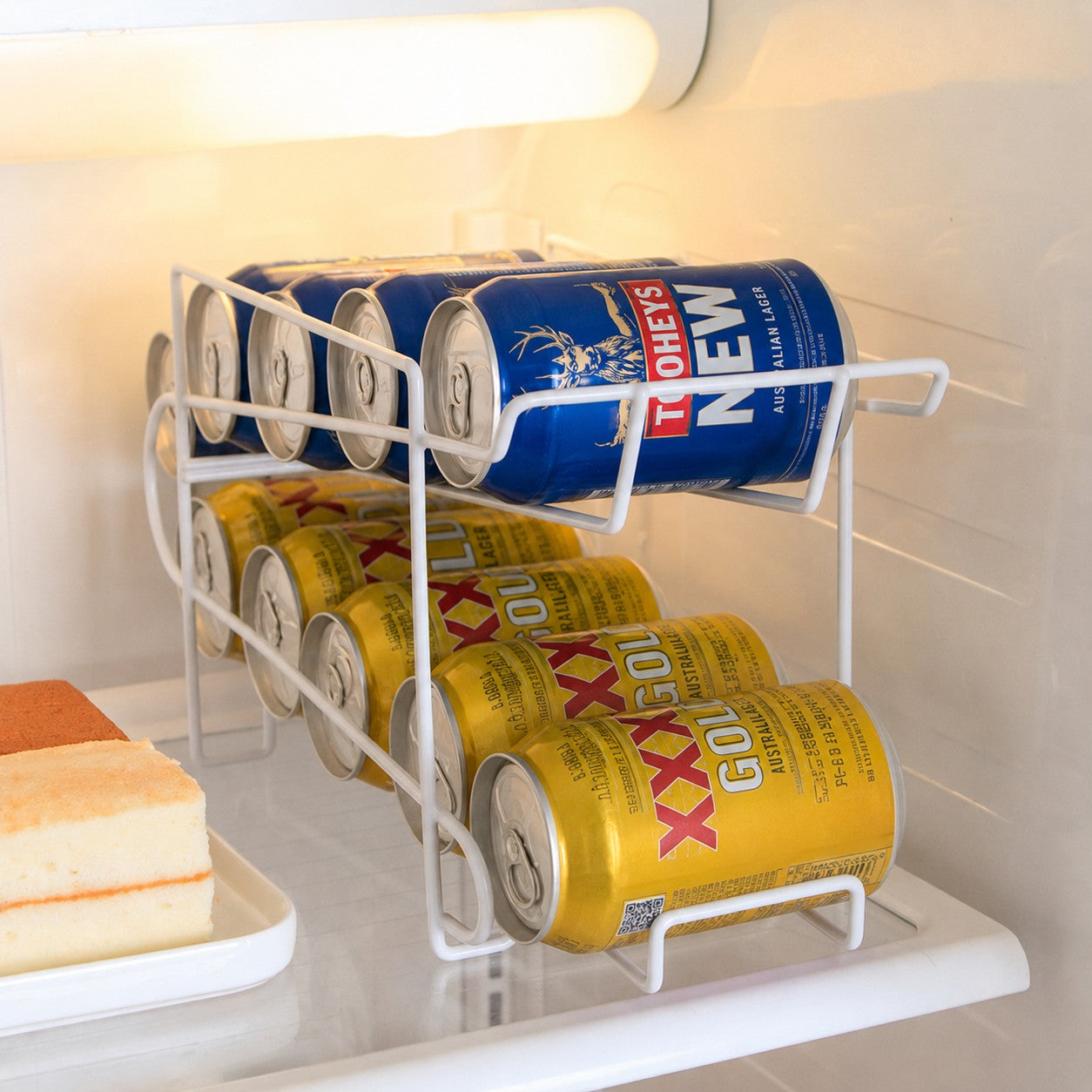 CanRoll white double-layer drink can organiser storing Tooheys New and XXXX beer cans inside a refrigerator