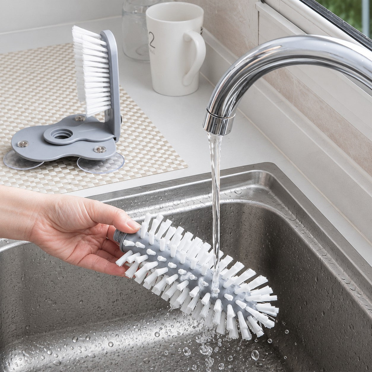 Removable CleanDock cup cleaning brush being rinsed under running water